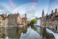 Houses reflection and boats on Dijver canal at dawn. Bruges, West Flanders province, Flemish region, Belgium.