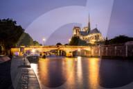 Notre Dame Cathedral and lights reflecting in the Seine on a wet evening in Paris.