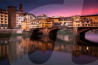 Ponte Vecchio at sunset reflecting in river Arno, Florence