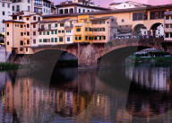 Ponte Vecchio at sunset reflecting in river Arno, Florence