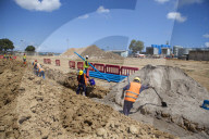 Workmen dig a trench and install a new pipeline.