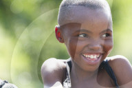A young girl smiling and looking off to the right.