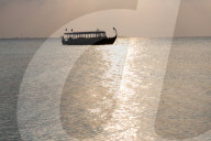 Wooden boat in silhouette at sunset, off Dhuni Kolhu, Baa Atoll, Republic of Maldives, Indian Ocean