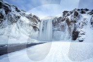 Winter view of Skogafoss waterfall, with cliffs covered in Icicles and foregreound covered in snow, Skogar, South Iceland