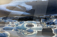 Ice arch among icebergs floating on Fjallsarlon lagoon, near Jokulsarlon, South Iceland