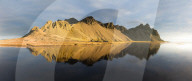 Panoramic view of mountains of Vestrahorn and perfect reflection in shallow water, soon after sunrise, Stokksnes, South Iceland
