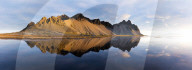Panoramic view of mountains of Vestrahorn and perfect reflection in shallow water, soon after sunrise, Stokksnes, South Iceland