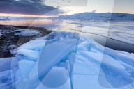 Sunset over frozen Jokulsarlon Glacial Lagoon in winter, South Iceland