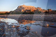 The ancient Kasbah Ait Benhaddou bathed in morning light and reflecting in river, near Ouarzazate, Morocco