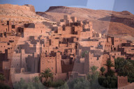 The ancient mud brick buildings of Kasbah Ait Benhaddou bathed in golden morning light, near Ouarzazate, Morocco