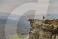 Walkers taking in the view on Hathersage Edge, Peak District National Park, Derbyshire, Ladybower Reservoir below.