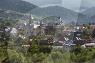 Town nestled in valley in foothills of Carpathian Mountains where churches are the dominant buildings in the village