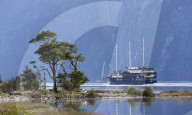 The Milford Mariner dwarfed by steep mountains, Milford Sound, Fiordland National Park, UNESCO World Heritage Site, Southland, South Island, New Zealand, Pacific