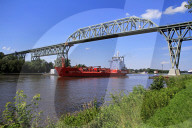 Ship on Kiel Canal going under the Railway Bridge of Hochdonn, Dithmarschen, Schleswig-Holstein, Germany