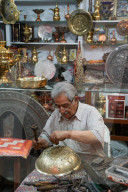 Metalworker,Two bazaaris chatting over the counter of a metalwork shop, Grand Bazaar, Isfahan, Iran