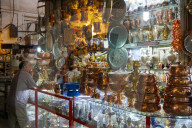 Two bazaaris chatting over the counter of a metalwork shop, Grand Bazaar, Isfahan, Iran