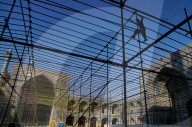 Silhouetted workman setting up marquee for special event in the courtyard of Imam Mosque, Isfahan, Iran