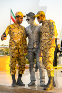 Two soldiers taking a selfie with a street performer, Tehran, Iran