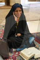 Young woman torn between her mobile and her religious reading, Aramgah-e Shah-e Cheragh (Mausoleum of the King of Light), Shiraz