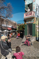Street tango dancer hamming it up with tourists outside a bar on the corner of El Caminito, La Boca, Buenos Aires, Argentina