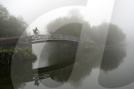 A cyclist on a bridge on Birmingham Canal Navigations, (BCN) Birmingham, West Midlands, UK.