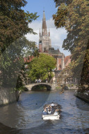 Bridge to Begijnhof, and Spire of St Salvatore Kirk, tourist launch, Bruges, World Heritage site. Belgium