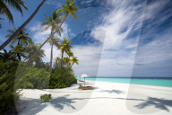 Lounge chairs under shade of umbrella on tropical beach, Maldives,Asia
