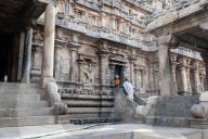 Woman in sari worshipping, doing puja to Lord Ganesh, at shrine on the side of Swaminathaswamy temple, Swamimalai, Tamil Nadu
