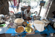 Chaat stall, man mixing sprouting seeds and lentils and puffed rice with spices, Dalhousie Square, Kolkata