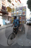 Piled up empty tins of oil, being carried by cycle rickshaw to be recycled and used for slum house walls, Kolkata