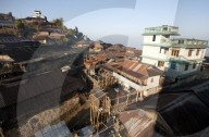 Naga village houses with bamboo stilted verandahs, clinging to the hilside, in morning light, Chanlangshu village, Nagaland