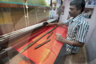 Silk weaver at his loom in his house, weaving sought after red and gold Kanchipuram silk sari, Kanchipuram, Tamil Nadu