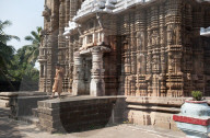 Hindu priest in saffron robes outside ornately carved 13th century Madhava temple dedicated to Lord Vishnu, Madhava, Odisha