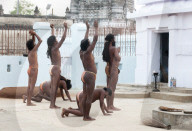 Joranda monks in saffron loincloths performing daily sunset devotional prayer ceremony at Joranda monastery, Odisha