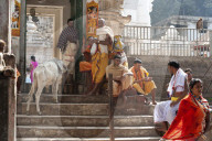 Hindu pilgrims in saffron and whiite robes, at the gate into Kapilash Temple (Chandrashekhar Temple), Dhenkanal District, Odisha