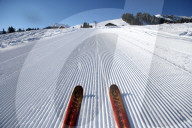 French Alps. Red pair of ski in snow. Groomed Ski Piste.