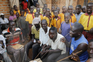 Ugandan villagers drinking home-brewed beer and schoolchildren.
