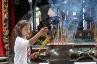 Taoist temple. Phuoc An Hoi Quan Pagoda. Incense sticks on joss stick pot are burning Buddhist Worshipper