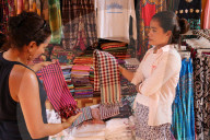 Woman buying scarves at Siem Reap market. Cambodia.