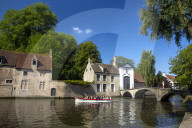 Tourist boat, at the Minnewater Lake and Begijnhof Bridge with entrance to Beguinage, Bruges, Belgium, Europe