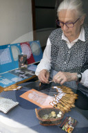 Old lady making lace by hand using pins and bobbins, Bruges, West Flanders, Belgium, Europe