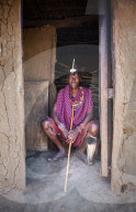 Portrait single Masai Mara man wearing traditional jewelry, headpiece and clothes, Masai Mara National Reserve, Kenya.