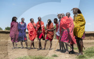 Masai Mara members sing tribal songs to greet guests to their village, Masai Mara National Reserve, Kenya.