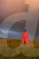 Portrait Masai Mara man wearing traditional tribal red blanket, Masai Mara National Park, Kenya.