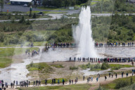 Tourists watch the eruption of the Strokkur geyser, Haukadalur valley, HvÃ­tÃ¡ River, Iceland.