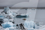 Boat amongst calved ice from the Breidamerkurjokull glacier in JÃ¶kulsÃ¡rlÃ³n glacial lagoon, Iceland.