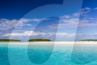 Coconut palm trees line the beach on One Foot Island, Aitutaki, Cook Islands.