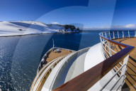 Cruise ship deck with couple in hot tub, off Half Moon Island, blue sky, evening sun, South Shetland Islands, Antarctica
