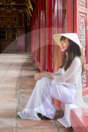 Young Vietnamese woman in a traditional Ao Dai dress and Non La conical hat