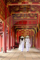 Vietnamese women in traditional Ao Dai dresses and Non La conical hats in the Forbidden Purple City of Hue